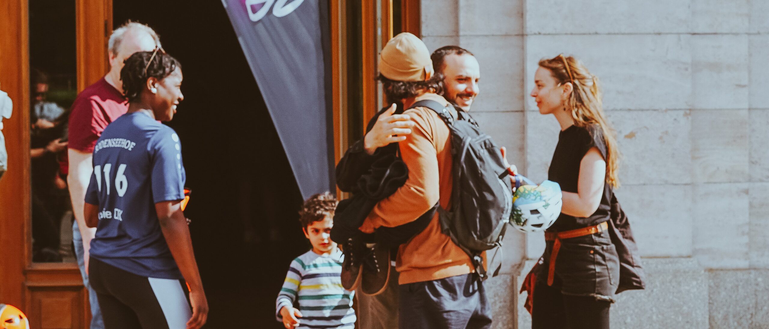 Two friends hugging and laughing at the entrance