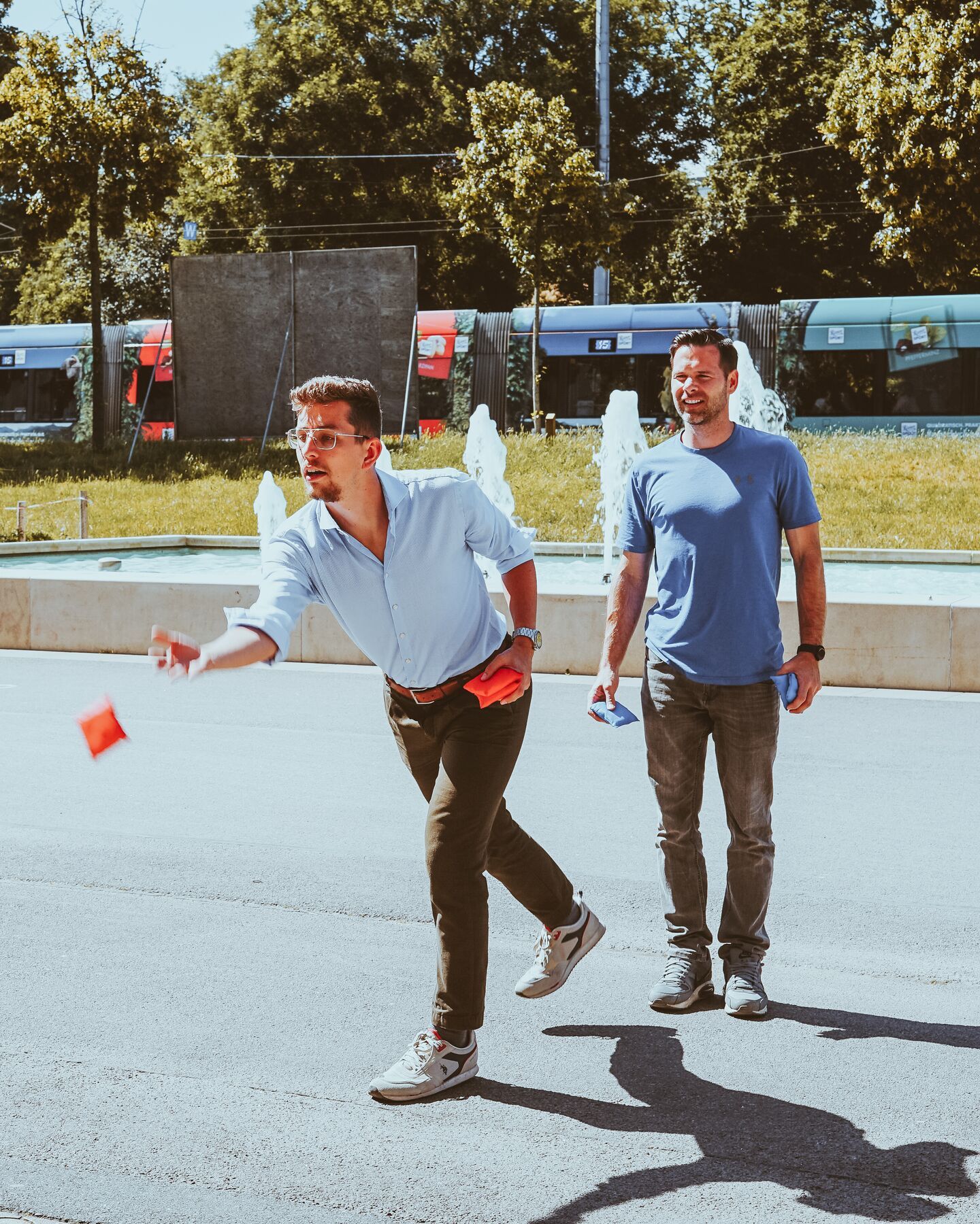 Two friends playing a throwing game outdoors on a sunny day