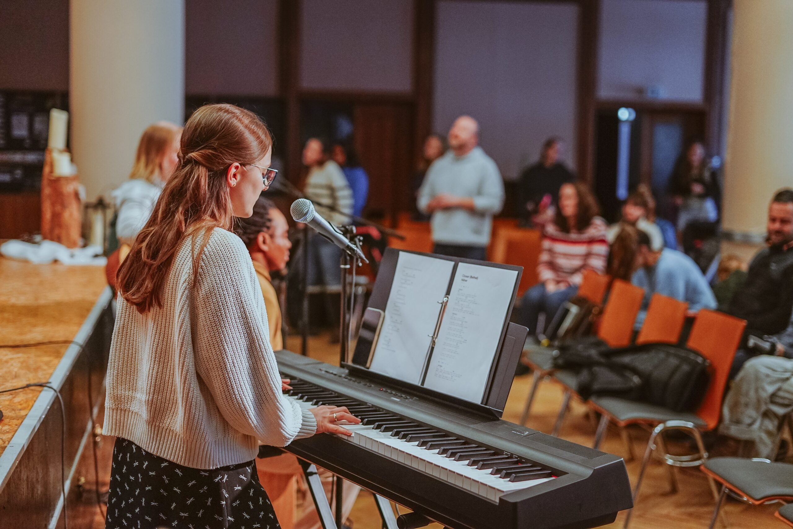 A young woman playing keyboard and singing in the worship team